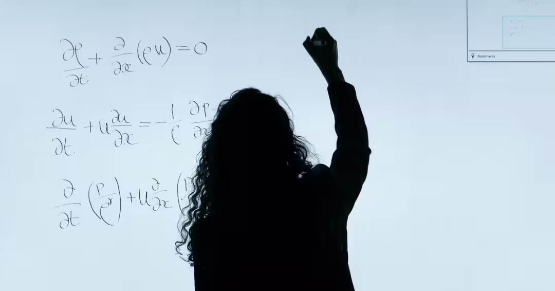 ホワイトボードで計算する女性の後ろ姿